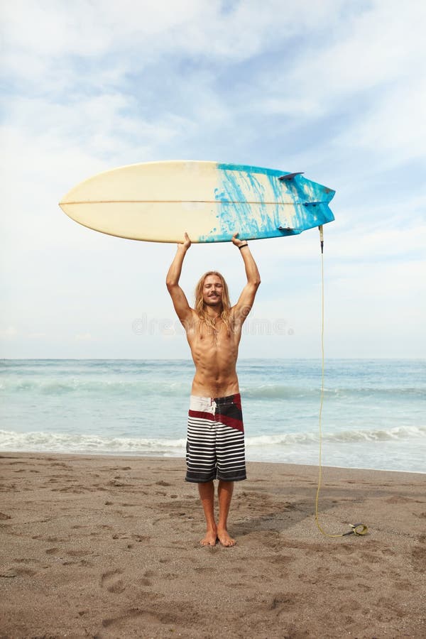 冲浪帅帅的冲浪者将白色冲浪板保持在头部上方沙滩画像上的笑人库存照片 图片包括有藏品 男性