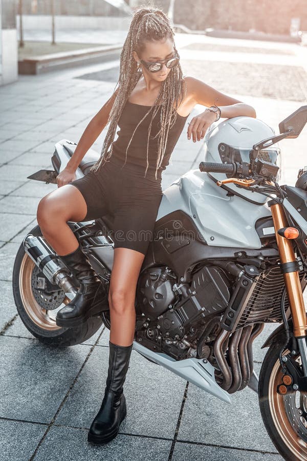 时髦的女人骑摩托车在人行道外库存照片 图片包括有藏品 成人 相当 妇女 垂直 户外 盔甲