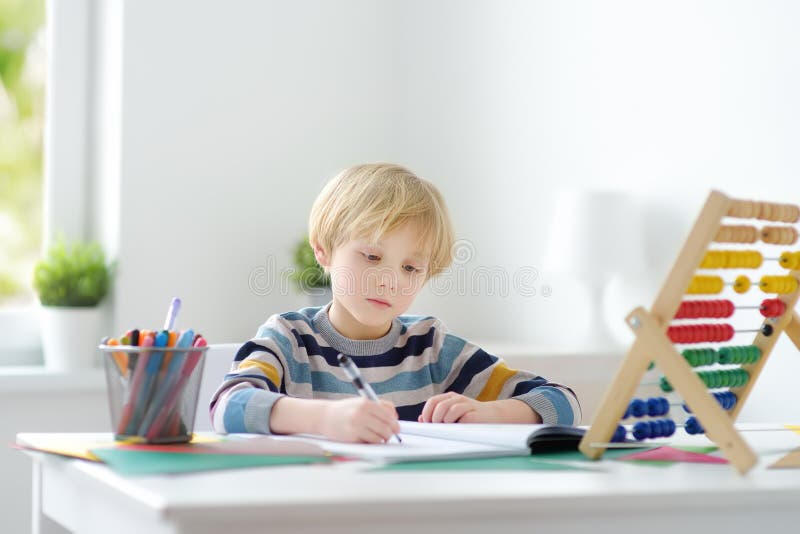 在家做家庭作业的小学生 儿童学习计数解算算术示例在工作簿中执行练习 库存图片 图片包括有问题 婴孩