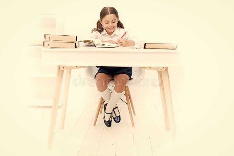 什么应该是高度研究桌做家庭作业的女小学生在桌上学习在桌上的可爱的