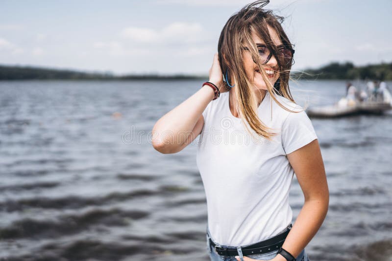 戴时髦眼镜的漂亮年轻女人的画像湖景背景上摆着白色t恤的女孩库存照片 图片包括有关闭 查找