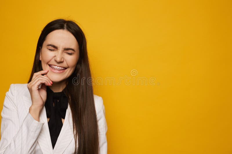 戴牙套的微笑年轻女子对着黄色背景闭着眼睛 孤立拉丁黑发美人库存图片 图片包括有特写镜头 健康 戴牙套的微笑年轻女子对着黄色背景闭着眼睛 孤立拉丁黑发美人库存图片 图片包括有特写镜头 健康