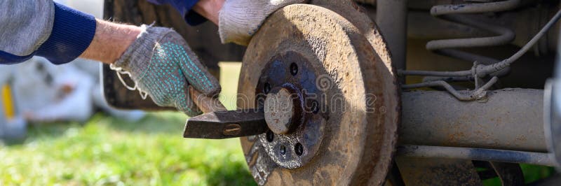 手套式汽车鼓式制动器自己修理 用锤子把卡住的盘子拆开 汽车鼓式制动器破损的修复库存照片 图片包括有阻塞 结构