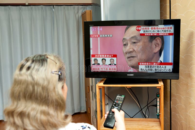 一名女性在电视上观看日本首相安倍晋三宣布进入紧急状态以遏制冠状病毒传播的消息图库摄影片 图片包括有社论 最初