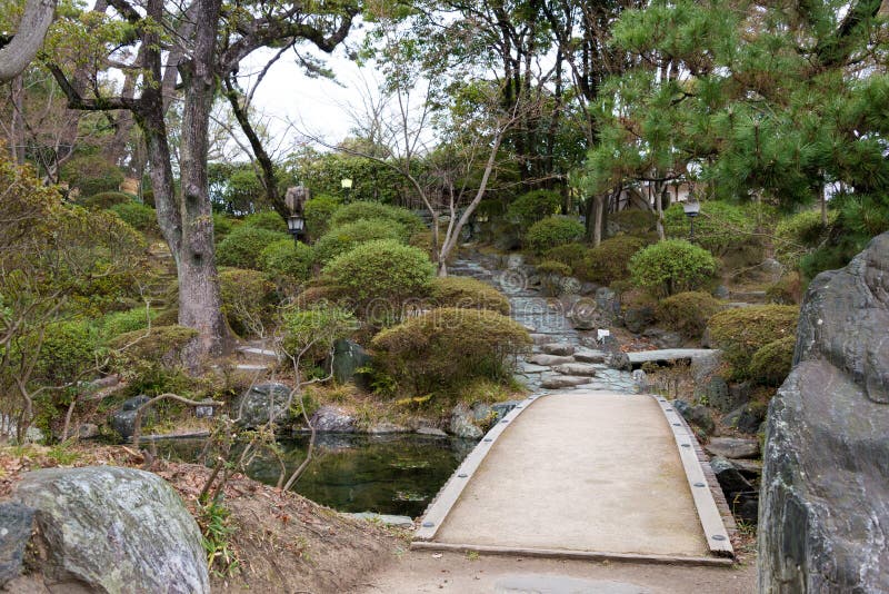 站立在与樱花的小山上面的和歌山城在foregound 库存图片 图片包括有拱道 历史记录 城堡
