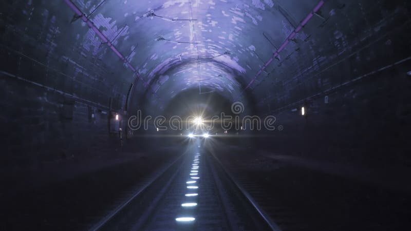 暗暗的铁路隧道里 有亮火车灯朝着摄像机库存照片 图片包括有