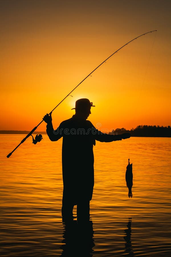 有一根钓鱼竿的一位渔夫在他的手和鱼上库存照片. 图片包括有铸件, 捕鱼