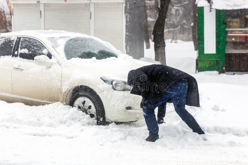 汽车阻拦与在城市街道上的雪漂泊在大雪 飞雪和风暴期间 供以人员从雪的清洁车与刷子w 库存图片 图片包括有