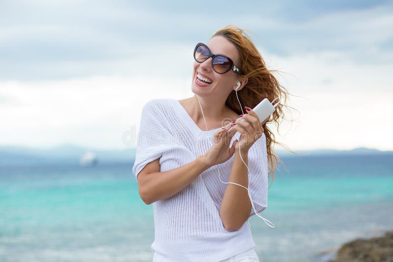 海蓝天背景的沙滩上 一个带耳机听音乐的微笑小女孩的画像库存照片 图片包括有拉丁语 音乐 海蓝天背景的沙滩上 一个带耳机听音乐的微笑小女孩的画像库存照片 图片包括有拉丁语 音乐