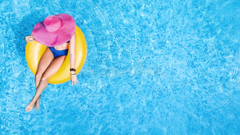 顶着帽子的美女 在泳池的天空中俯瞰 年轻女人在充气环圈上放松和游泳库存图片 图片包括有