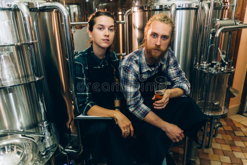 在啤酒厂或啤酒厂工作的带夹板的女性啤酒厂工人在精酿啤酒中打开啤酒桶盖库存图片 图片包括有打赌的人 整除数