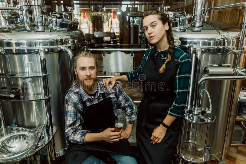 在啤酒厂或啤酒厂工作的带夹板的女性啤酒厂工人在精酿啤酒中打开啤酒桶盖库存图片 图片包括有打赌的人 整除数