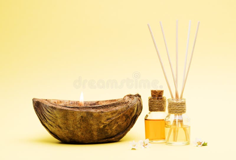 Fragrant Oil Diffuser with Reed Sticks and a Burning Candle in Coconut