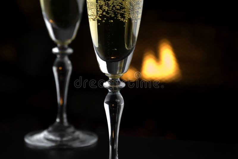 Shallow focus view of 2 glasses of champagne by the fire. Suitable for queit getaways, Valentines Day, Christmas holidays and others. Shallow focus view of 2 glasses of champagne by the fire. Suitable for queit getaways, Valentines Day, Christmas holidays and others.