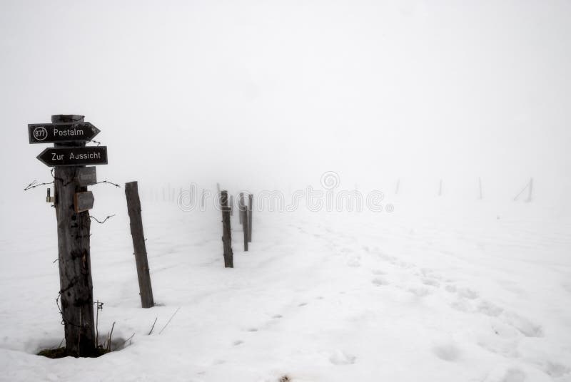 Way sign in deep snow an fog in the Alps. Way sign in deep snow an fog in the Alps