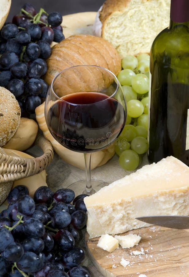 A glass of Chianti wine with assorted breads, cheese and grapes. A glass of Chianti wine with assorted breads, cheese and grapes