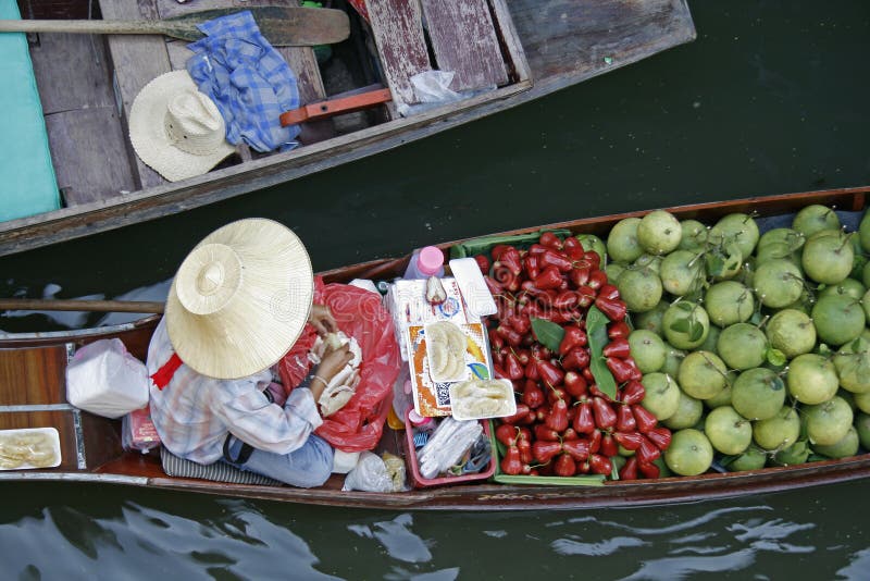 A fruit vendor in a boat at floating market near Bangkok, Thailand. A fruit vendor in a boat at floating market near Bangkok, Thailand