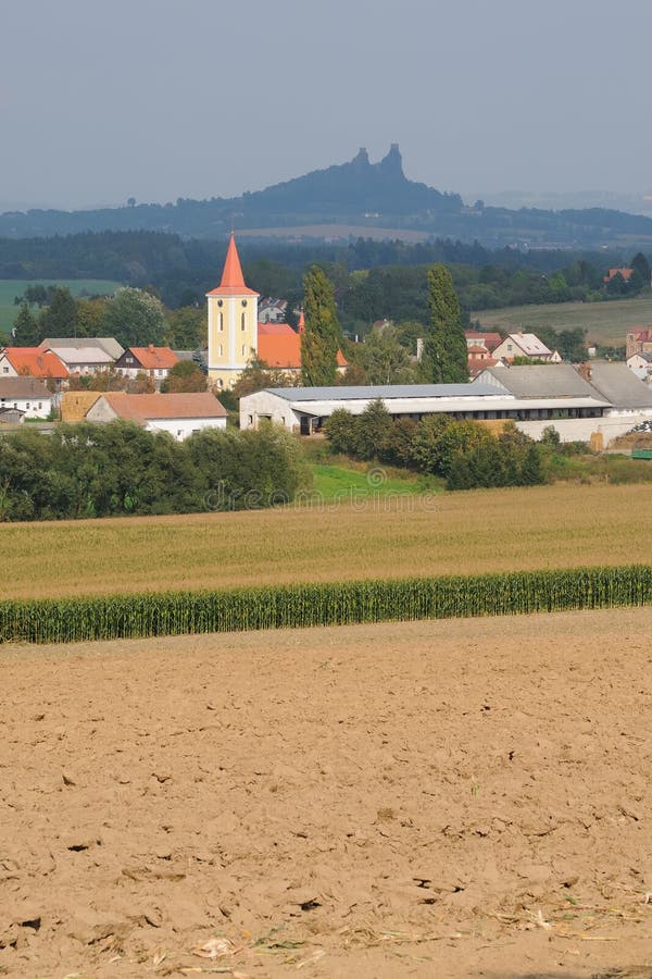 Church tower in a small village illuminated by sunlight an acre in the foreground. Church tower in a small village illuminated by sunlight an acre in the foreground