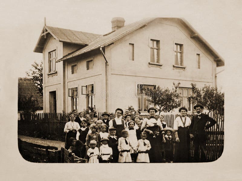 Vintage rural scene, ancient photo of a group of people in front of a house. Vintage rural scene, ancient photo of a group of people in front of a house