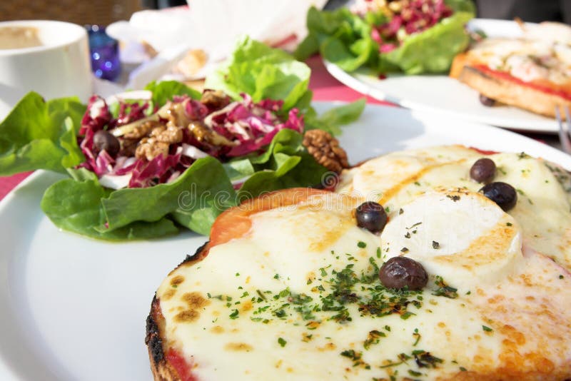 Pizza with cheese. Salad in the background. Shallow D.O.F - pizza in focus, salad out of focus. Pizza with cheese. Salad in the background. Shallow D.O.F - pizza in focus, salad out of focus.