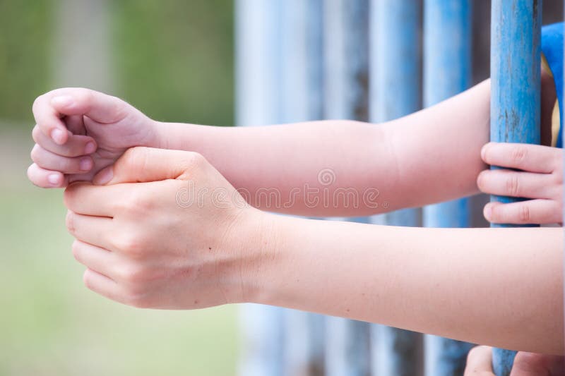 An image of a refugee behind bars. An image of a refugee behind bars