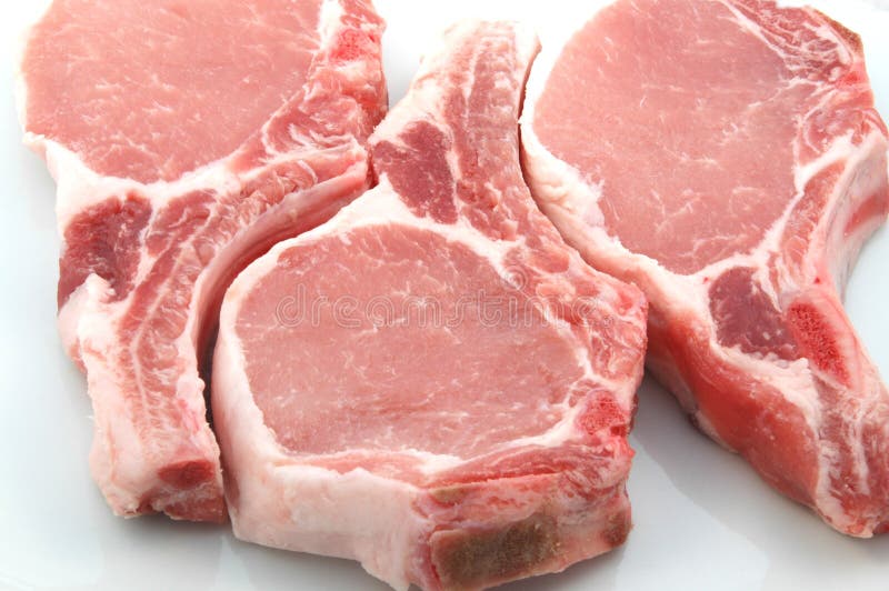 Three plump center cut pork chops on white. Three plump center cut pork chops on white