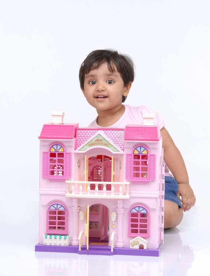 2-3 years old baby girl sitting behind the doll house. 2-3 years old baby girl sitting behind the doll house