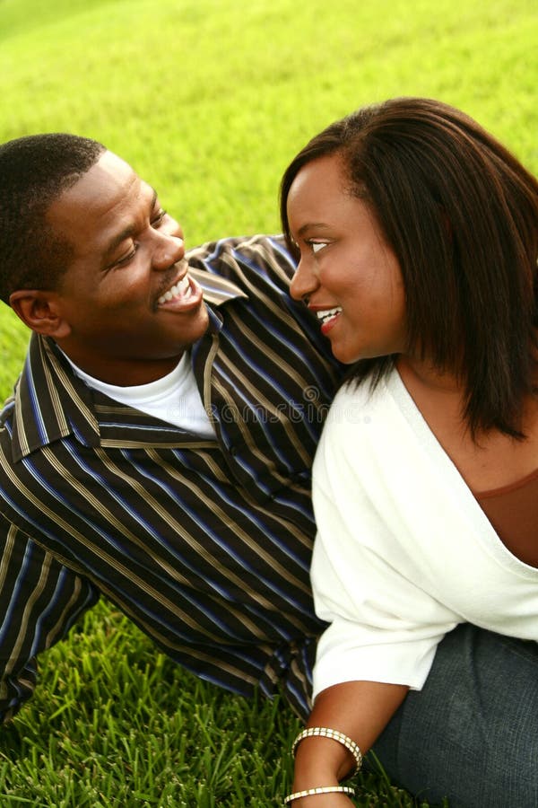 African american couple posing on the grass in an outdoor park. African american couple posing on the grass in an outdoor park