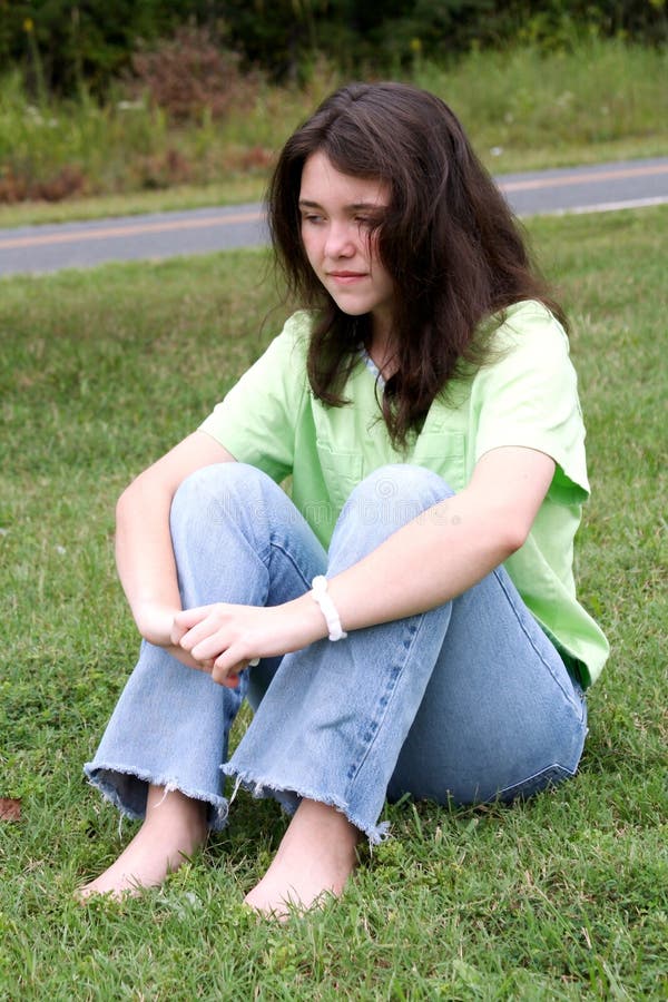 Teen girl in deep thought on grass. Teen girl in deep thought on grass