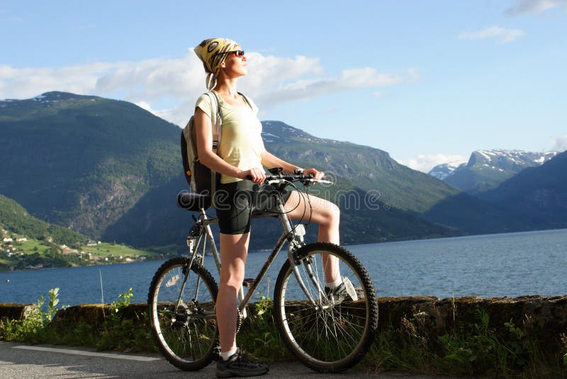 Healthy woman on her bike trip in the mountains over the lake. Healthy woman on her bike trip in the mountains over the lake