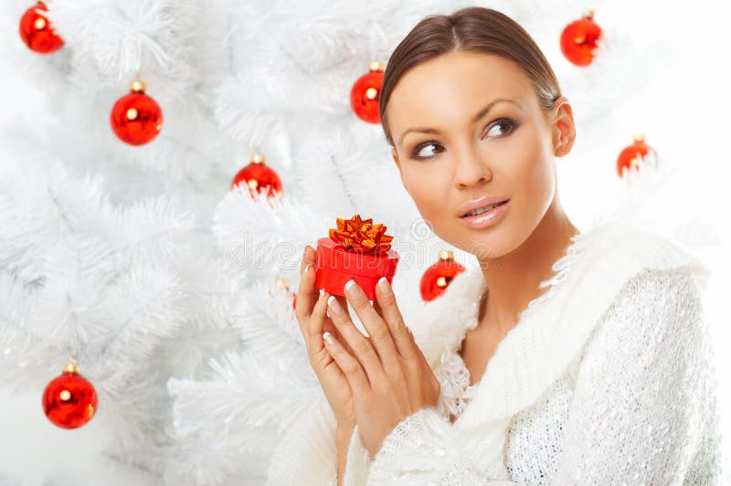 20-25 years old beautiful woman next to christmas tree on white background. 20-25 years old beautiful woman next to christmas tree on white background