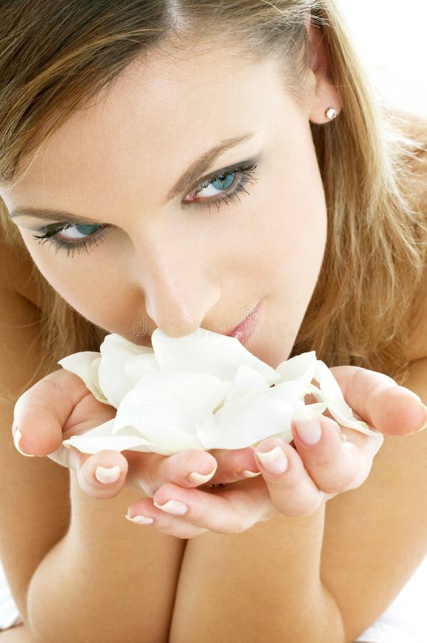 Lovely woman in spa smelling white rose petals. Lovely woman in spa smelling white rose petals