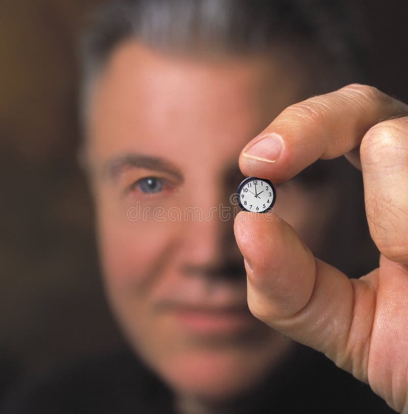 Closeup of man holding tiny clock. Closeup of man holding tiny clock