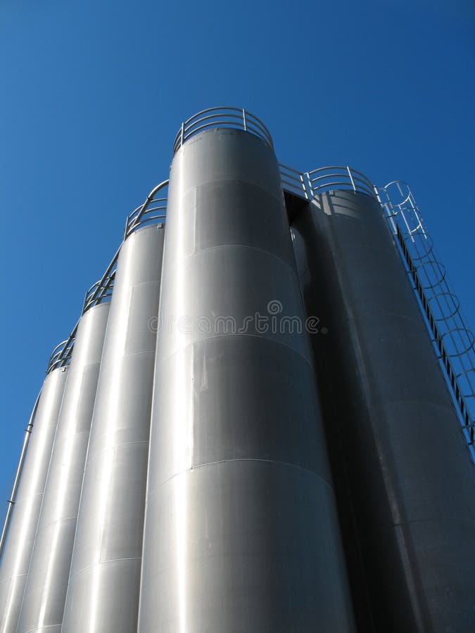 Tanks of silvery color, are photographed on a background of the blue sky. Tanks of silvery color, are photographed on a background of the blue sky