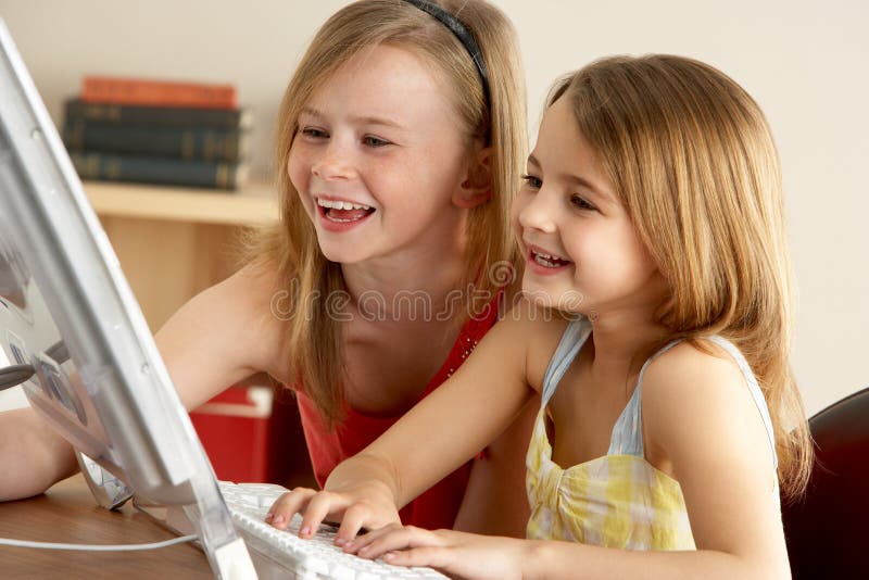Smiling young girl, 2 Young Girls Using Computer At Home. Smiling young girl, 2 Young Girls Using Computer At Home