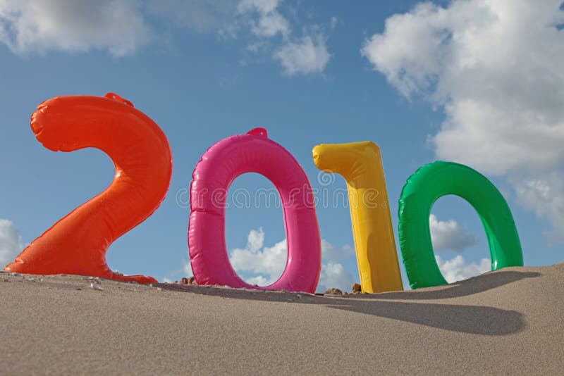 The year 2010 with inflatable numbers on the beach in front of a bright blue sky. The year 2010 with inflatable numbers on the beach in front of a bright blue sky.