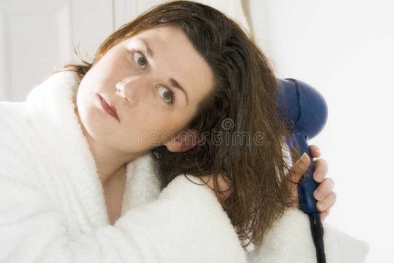 Beautiful young woman is drying her hair after the shower. Beautiful young woman is drying her hair after the shower