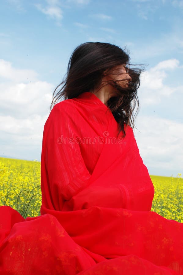 Young woman, black hair, hair in the wind, red clothes and contrasted background. Young woman, black hair, hair in the wind, red clothes and contrasted background