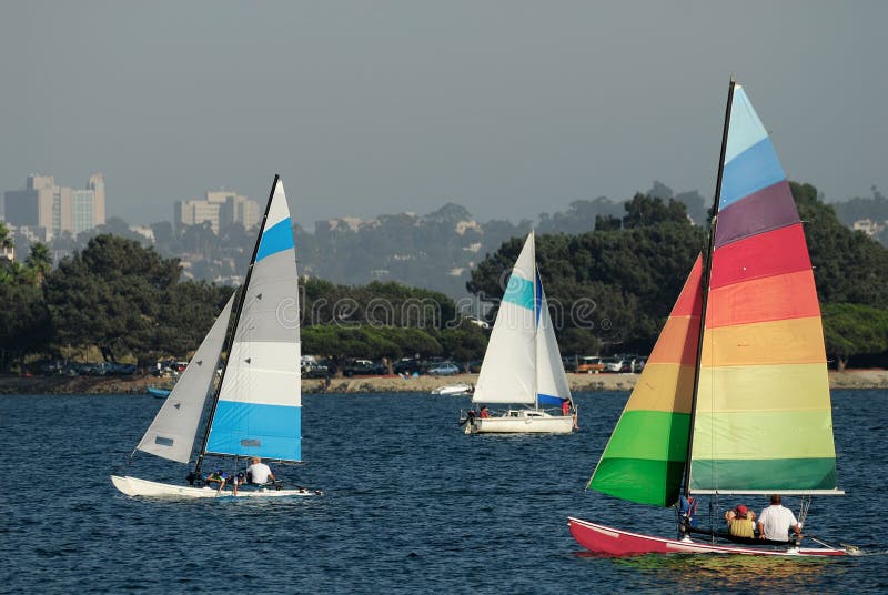 Two yachts and a catamaran are sailing in a Mission Bay, California on a nice summer afternoon. Two yachts and a catamaran are sailing in a Mission Bay, California on a nice summer afternoon.