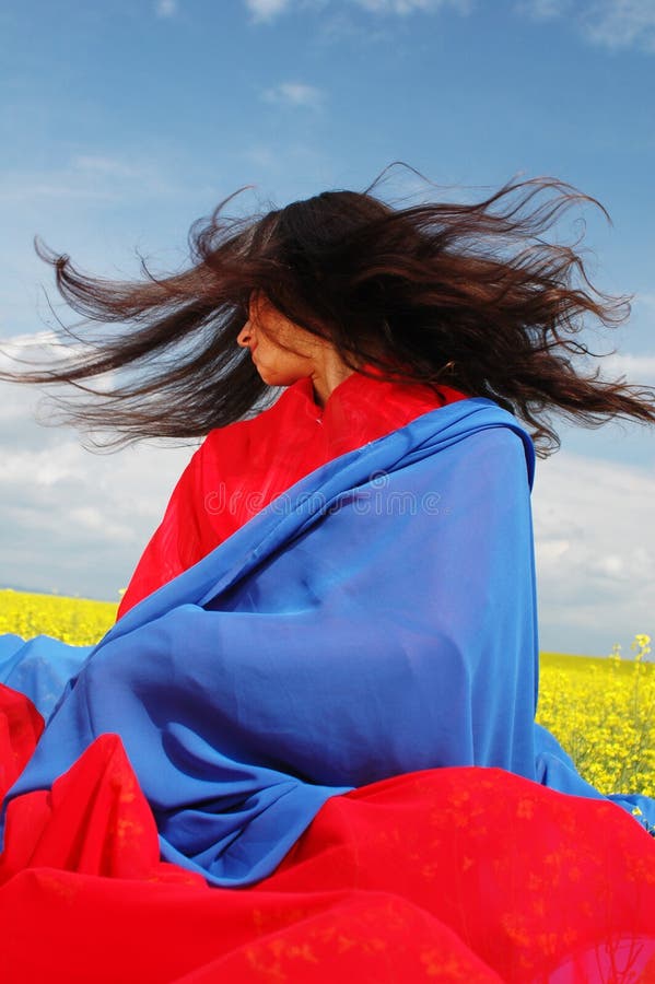 Girl in the meadows, asian-style dressed, live colours, hair in the wind. Girl in the meadows, asian-style dressed, live colours, hair in the wind