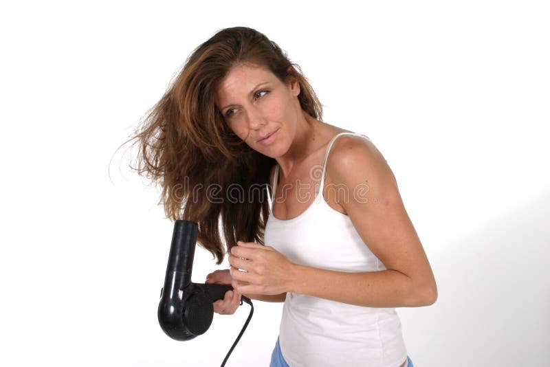 Beautiful brunette woman drying her hair with a blow dryer. Beautiful brunette woman drying her hair with a blow dryer.