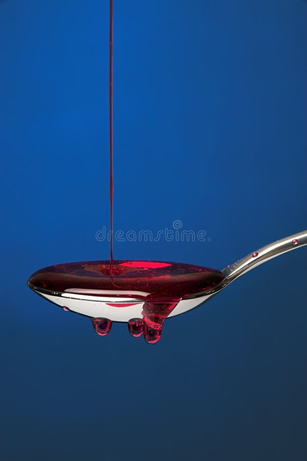 Spoon full of cough medicine over a blue backdrop 3. Spoon full of cough medicine over a blue backdrop 3