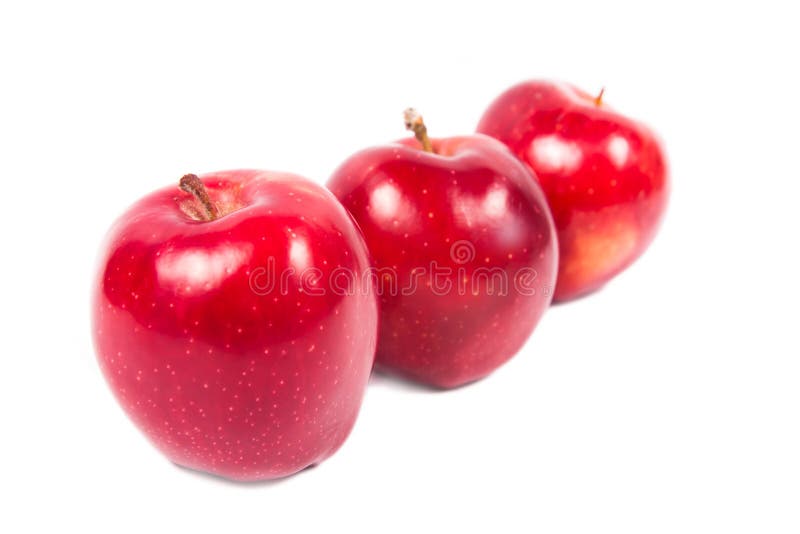 Three red apples stand in one row on a white background. Three red apples stand in one row on a white background