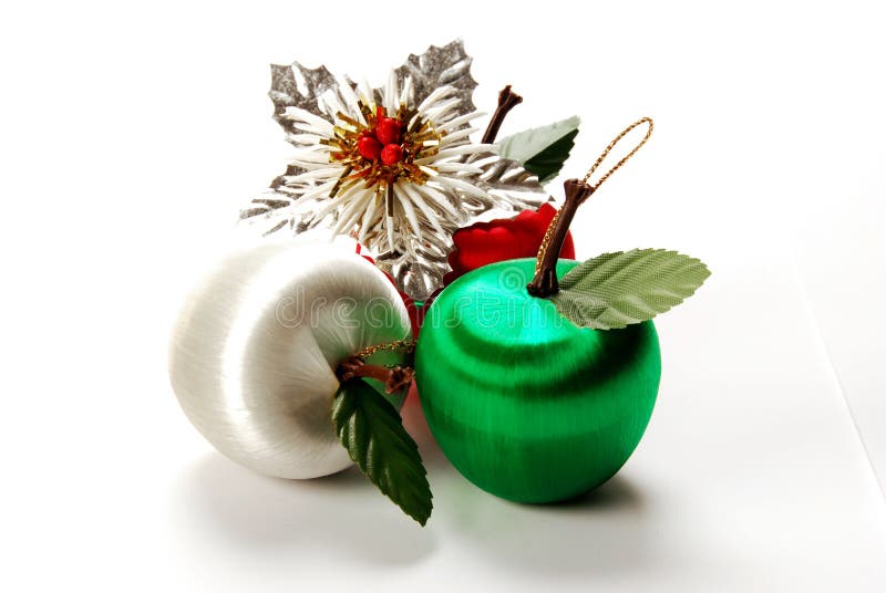 A selection of 3 coloured christmas apple decoration and a silver bauble isolated on a white background. A selection of 3 coloured christmas apple decoration and a silver bauble isolated on a white background