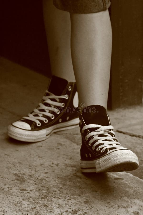 Girl in converse sneakers posing, sepia vintage retro style. Girl in converse sneakers posing, sepia vintage retro style