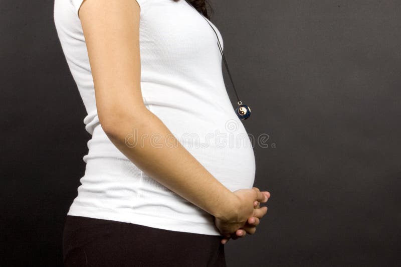 30 weeks pregnant teenager holding belly