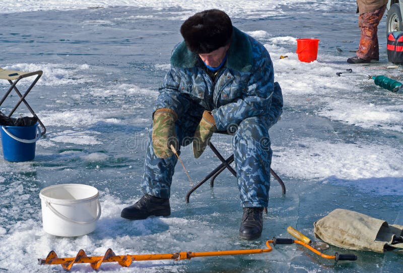 A man on winter fishing on ice of river. A man on winter fishing on ice of river.