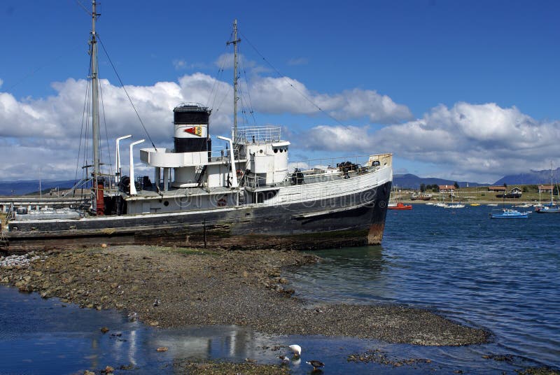 Aan de grond gezete die sleepbootboot in Ushuaia-Haven wordt verlaten royalty-vrije stock afbeelding Aan de grond gezete die sleepbootboot in Ushuaia-Haven wordt verlaten royalty-vrije stock afbeelding