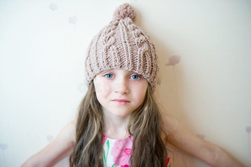 Aanbiddelijk glimlachend kindmeisje in beige gebreide hoed stock foto Aanbiddelijk glimlachend kindmeisje in beige gebreide hoed stock foto