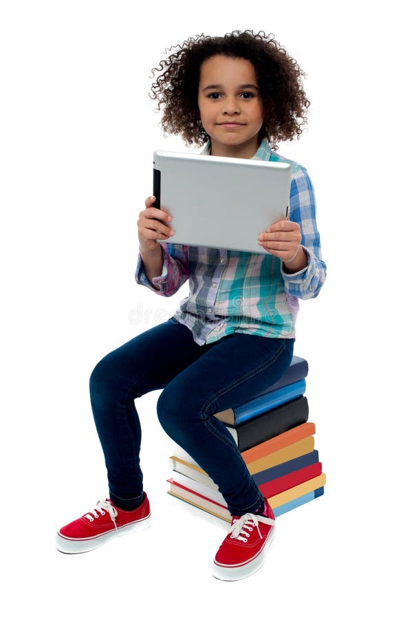 Aanbiddelijk jong geitje met de zitting van tabletpc op boeken royalty-vrije stock foto's Aanbiddelijk jong geitje met de zitting van tabletpc op boeken royalty-vrije stock foto's